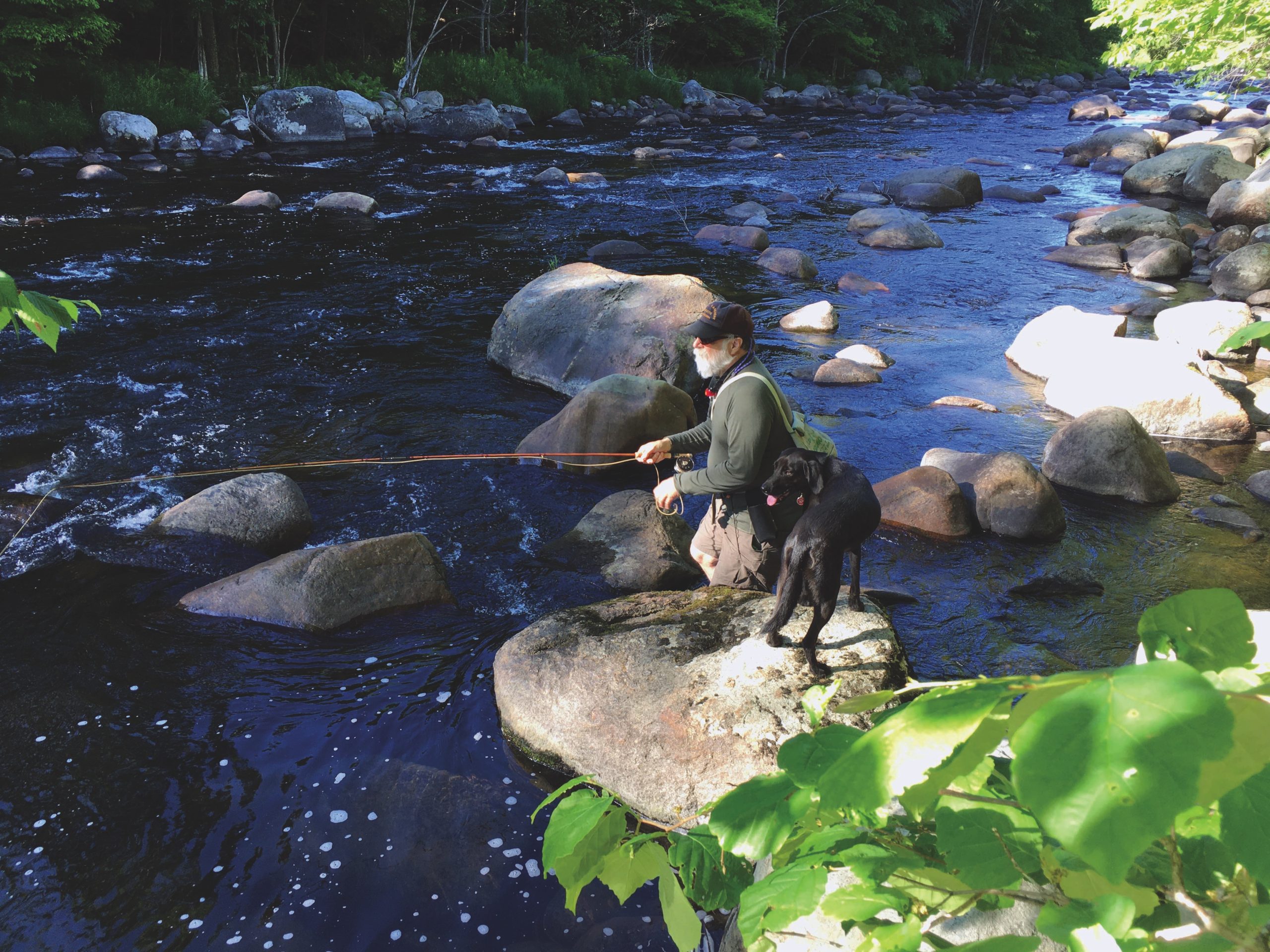 Artist Joseph Grigely on the Ausable River with his dog, Ollie
